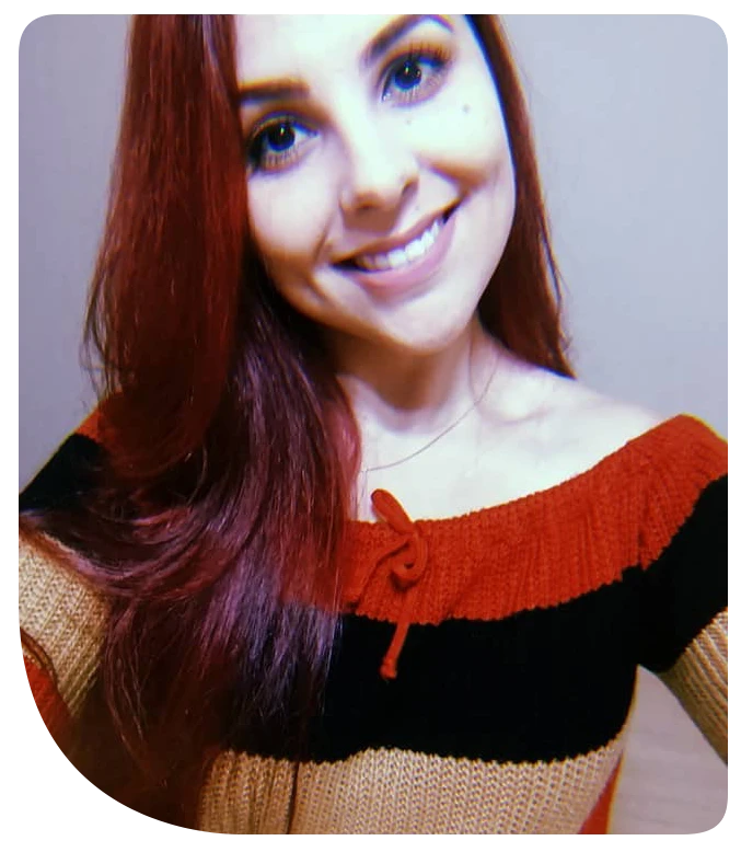 Professora de inglês Amanda, sorrindo, vestindo suéter listrado vermelho e preto, ideal para cursos e aulas de inglês.